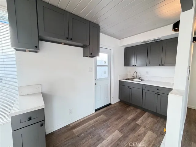 a kitchen with a sink cabinets and wooden floor
