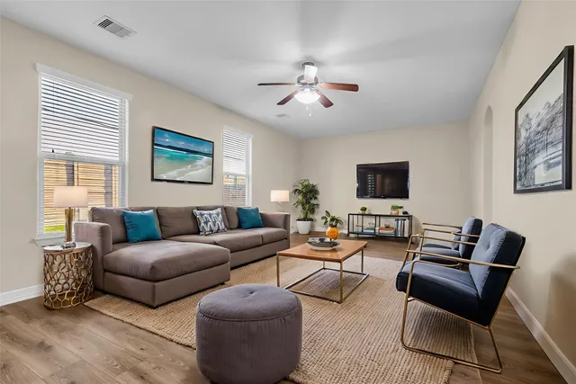 a living room with furniture a flat screen tv and a window