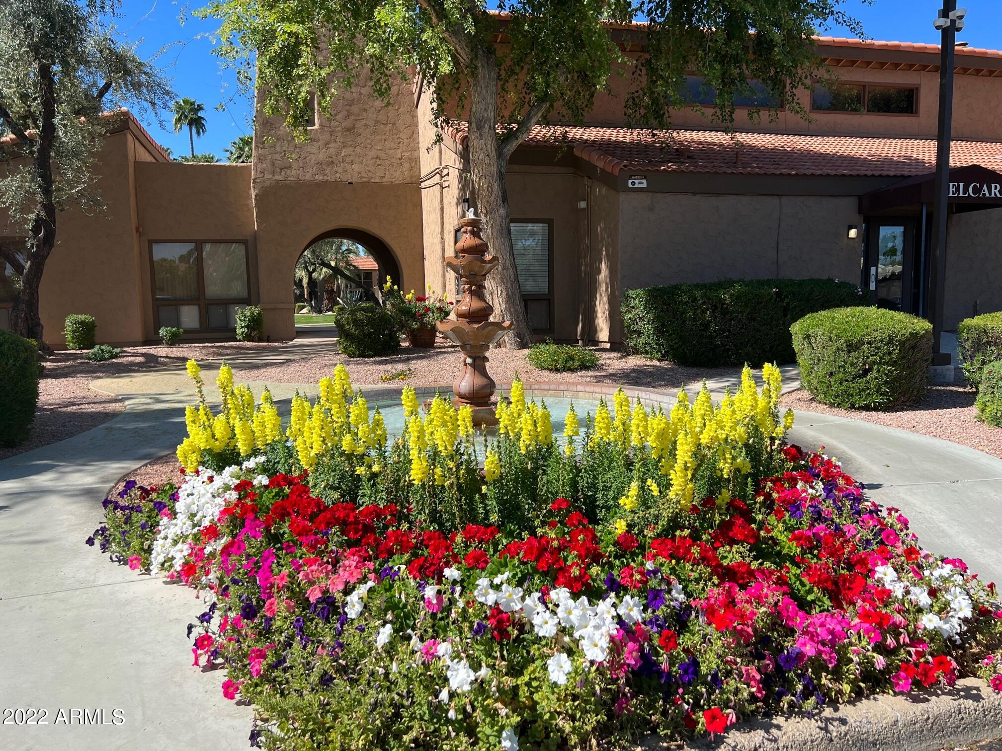 8256 East Arabian Trail, Unit 132 Scottsdale, AZ 85258 - Photo 4 of 19 a front view of a house with a yard and fountain