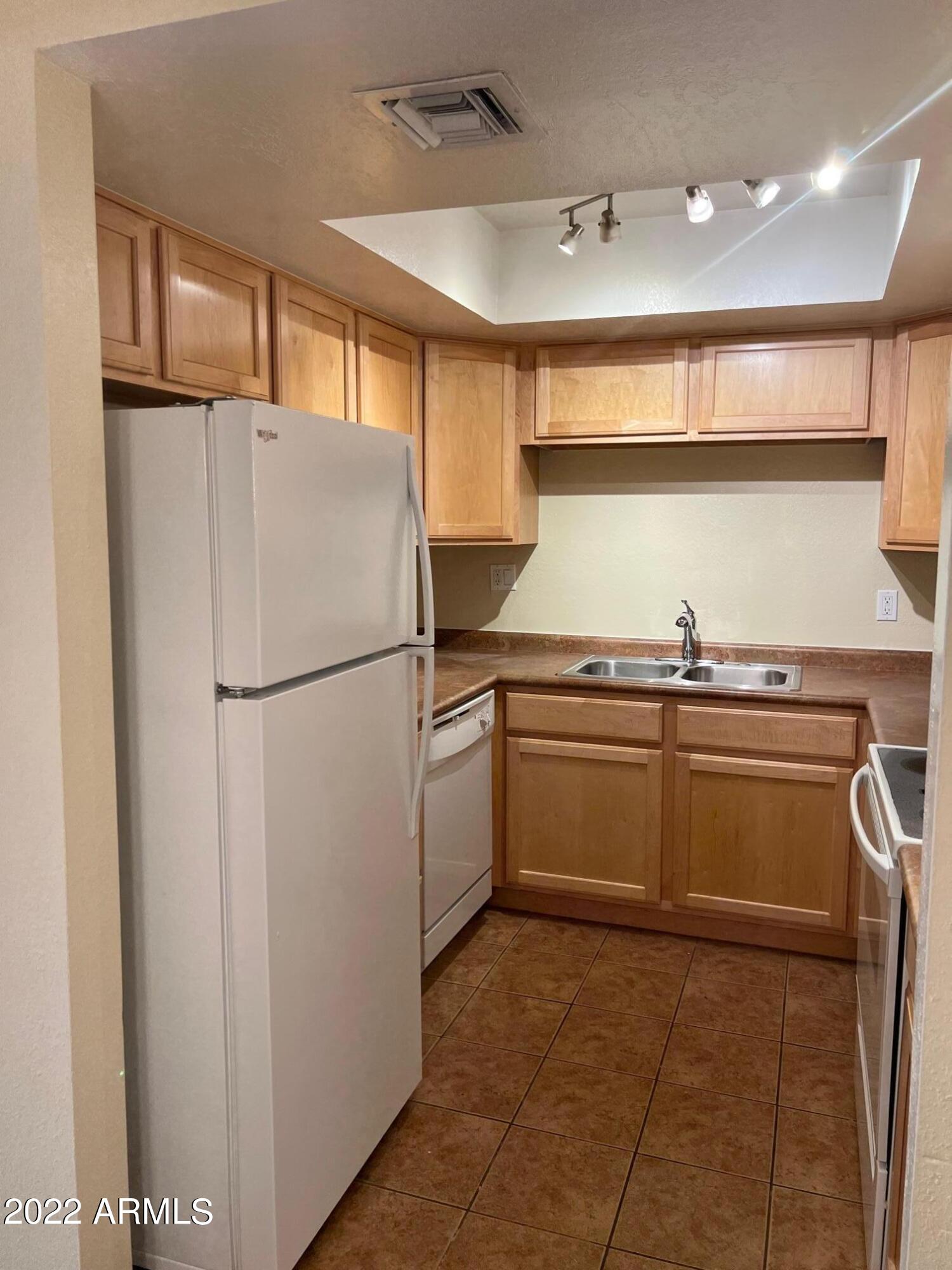 8256 East Arabian Trail, Unit 132 Scottsdale, AZ 85258 - Photo 7 of 19 a kitchen with a refrigerator and a sink