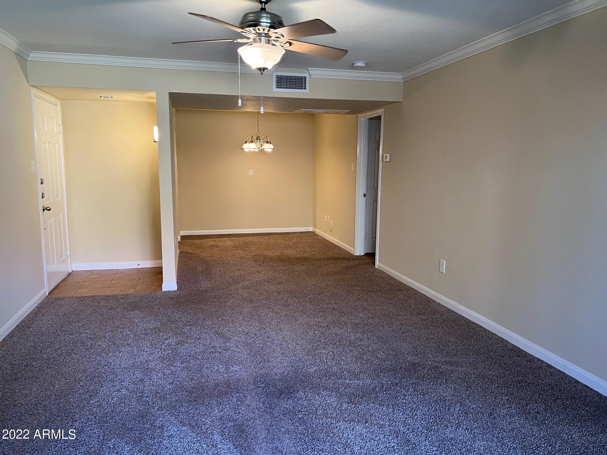 8256 East Arabian Trail, Unit 132 Scottsdale, AZ 85258 - Photo 9 of 19 an empty room with a chandelier fan and windows