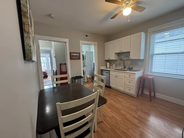 a kitchen with stainless steel appliances granite countertop a sink dishwasher a stove refrigerator and cabinets with wooden floor