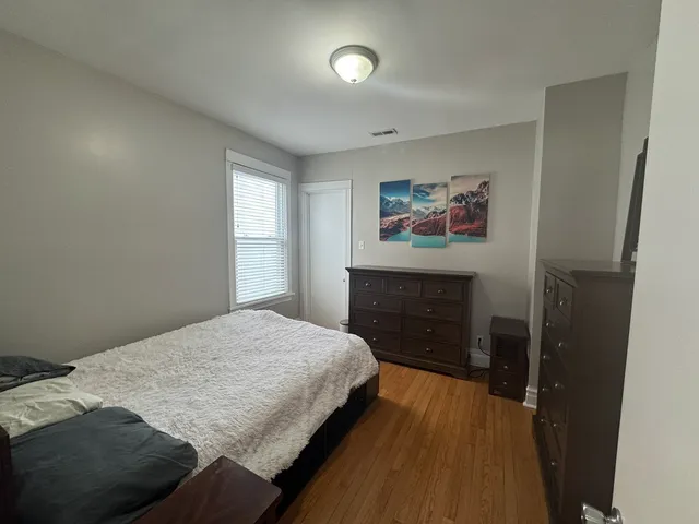a bedroom with a bed and a painting on the wall