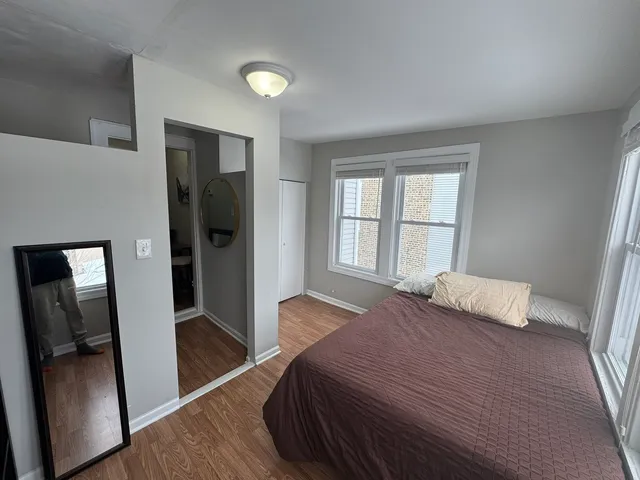 a bedroom with a bed and wooden floor