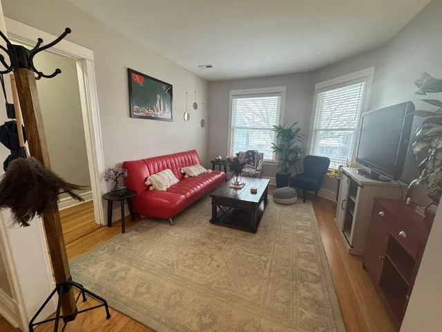 a living room with furniture a window and a flat screen tv