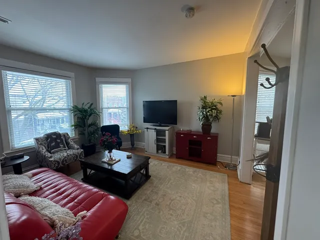 a living room with furniture a flat screen tv and a large window