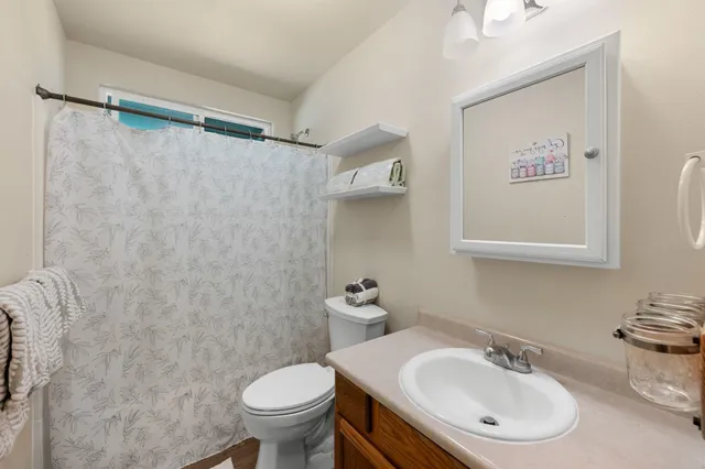 a bathroom with a sink toilet and a mirror