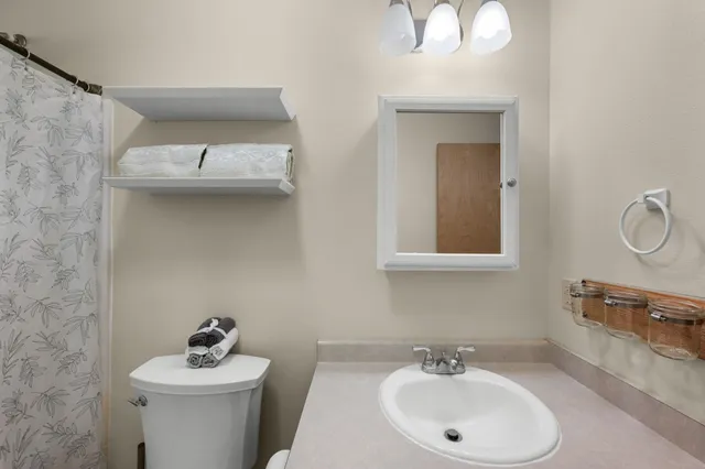 a bathroom with a sink a toilet and mirror