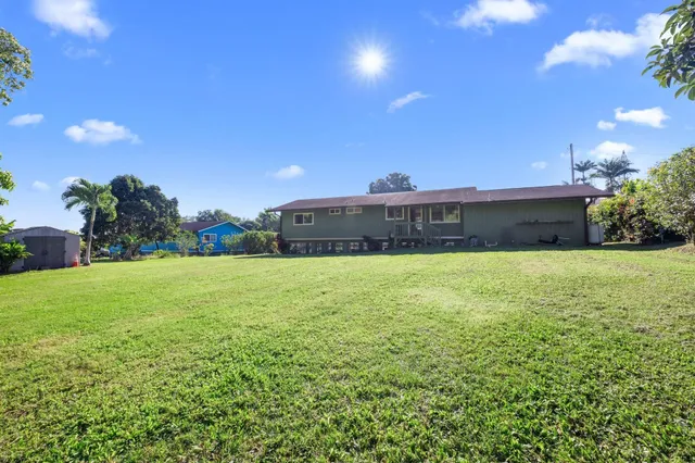 a view of a big yard with a house in the background