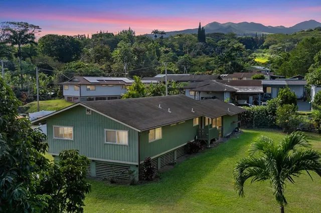 a aerial view of a house with a yard table and chairs