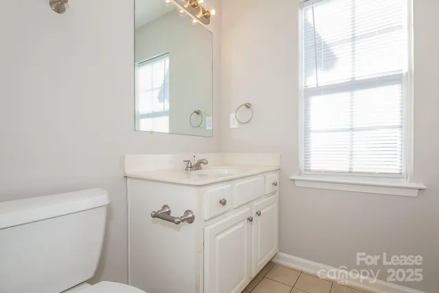 a bathroom with a sink a toilet and a window