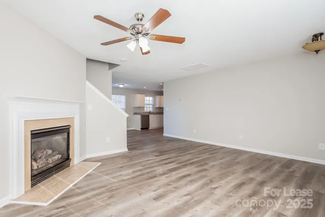 an empty room with a fireplace and wooden floor