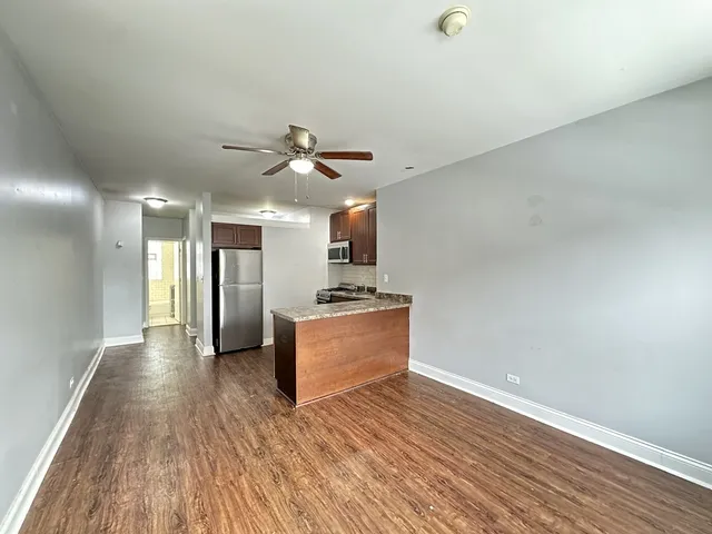 a view of a kitchen with a sink and a refrigerator