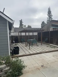 a view of house with a patio and a yard