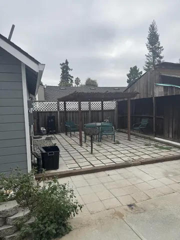 a view of house with a patio and a yard