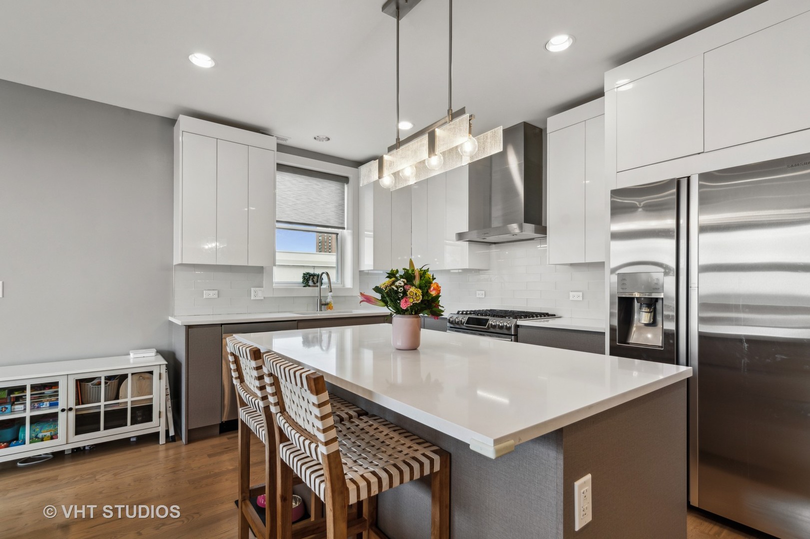 1209 East 46th Street, Unit 4E Chicago, IL 60653 - Photo 5 of 15 a kitchen with stainless steel appliances a table chairs in it and wooden floors