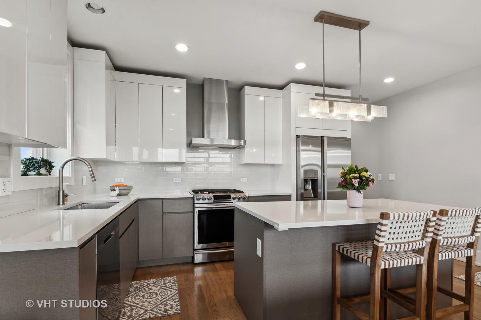 1209 East 46th Street, Unit 4E Chicago, IL 60653 - Photo 6 of 15 a kitchen with stainless steel appliances kitchen island granite countertop a sink a stove a dining table and chairs