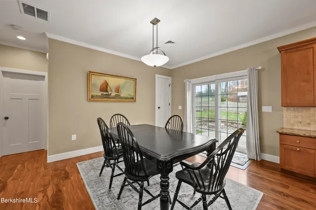 a dining room with furniture a chandelier and wooden floor