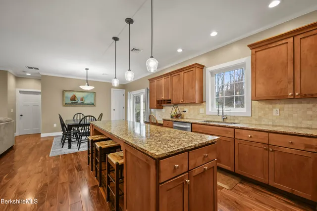 a bathroom with a granite countertop sink a toilet and a mirror