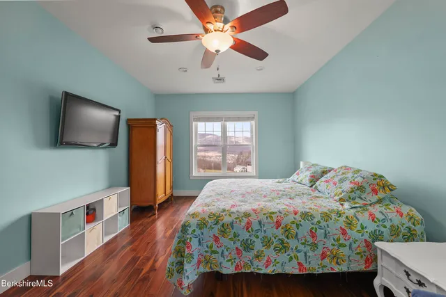 a bedroom with a bed a flat screen tv and a chandelier