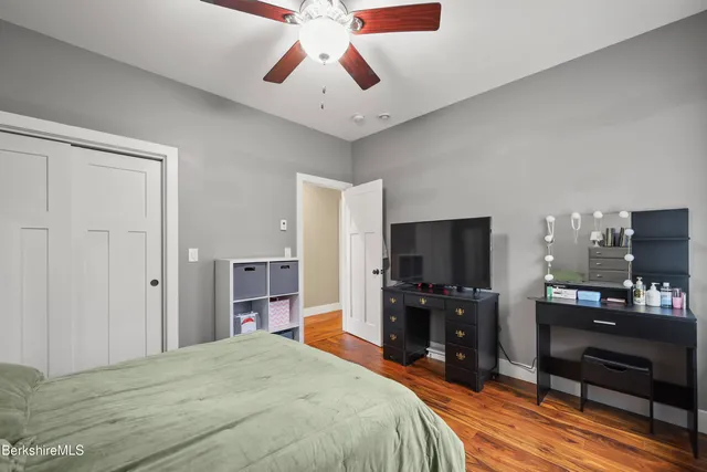 a bedroom with a bed a book shelf and a window