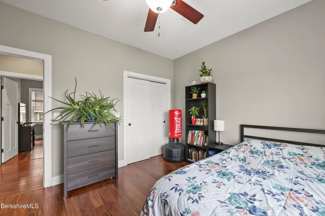 a bedroom with a bed and wooden floor