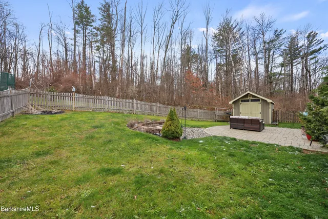 a backyard view of a house with basket ball court tables and chairs