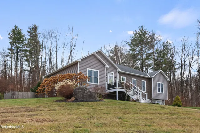 a front view of a house with a garden and trees