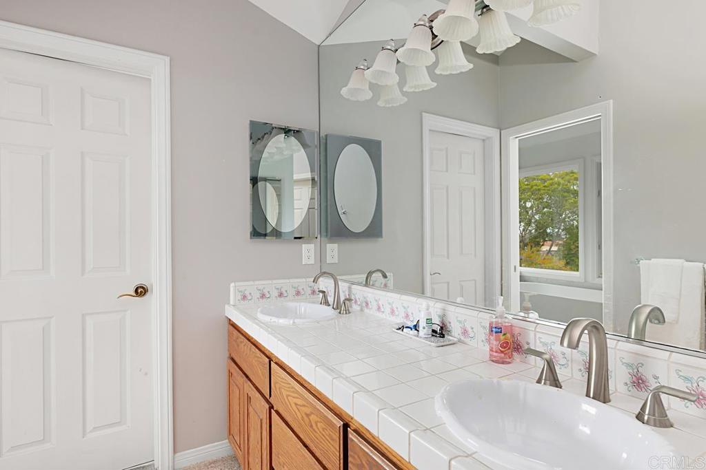 1369 Cherrytree Court Encinitas, CA 92024 - Photo 22 of 41 a bathroom with a double vanity sink and a mirror