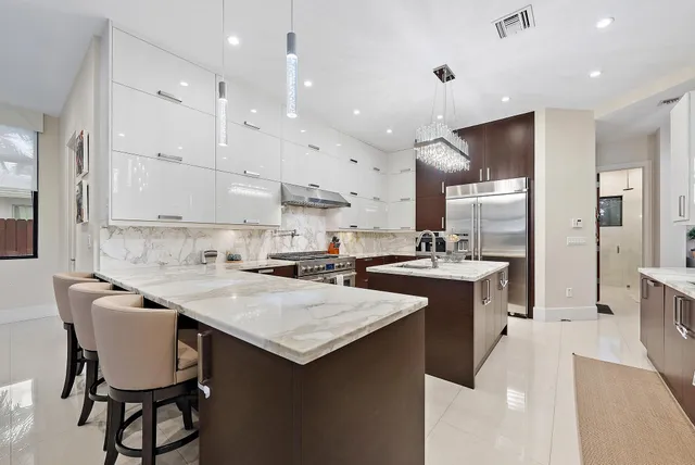 a kitchen with kitchen island a sink counter and chairs