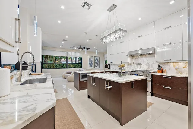 a kitchen with kitchen island a sink stove and a large window