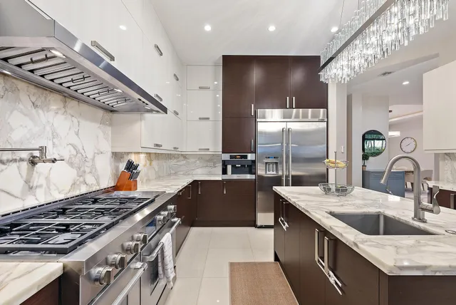 a kitchen with stainless steel appliances granite countertop a sink a stove and a wooden floors