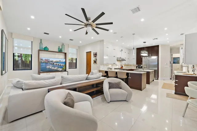 a living room with furniture kitchen view and a large window