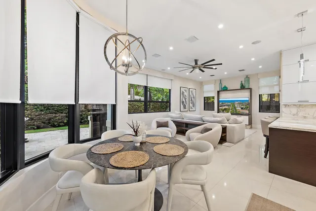a living room with furniture a chandelier and a dining table