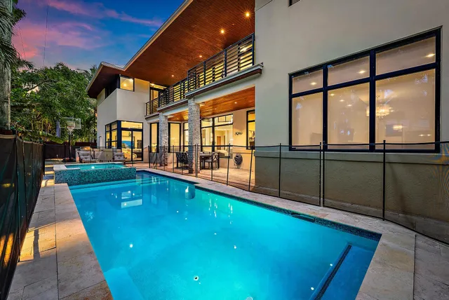 a swimming pool with outdoor seating and a garden