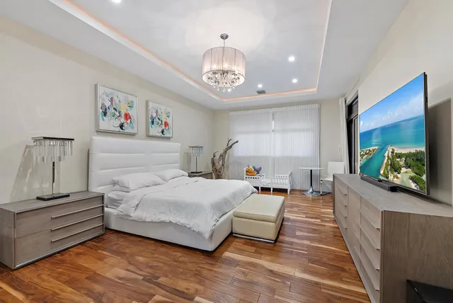 a bedroom with a large bed and a chandelier