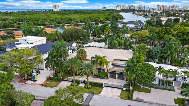 an aerial view of residential houses with outdoor space and trees