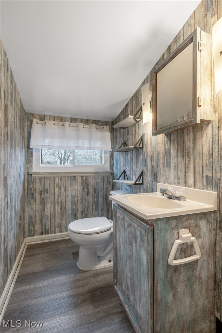 4220 3rd Street Northwest Canton, OH 44708 - Photo 8 of 11 Bathroom featuring hardwood / wood-style floors, vanity, toilet, and wood walls