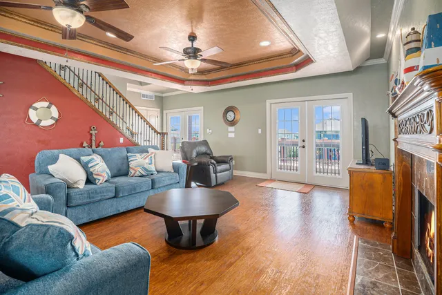 a kitchen with stainless steel appliances granite countertop a refrigerator a sink dishwasher a stove and a dining table with wooden floor