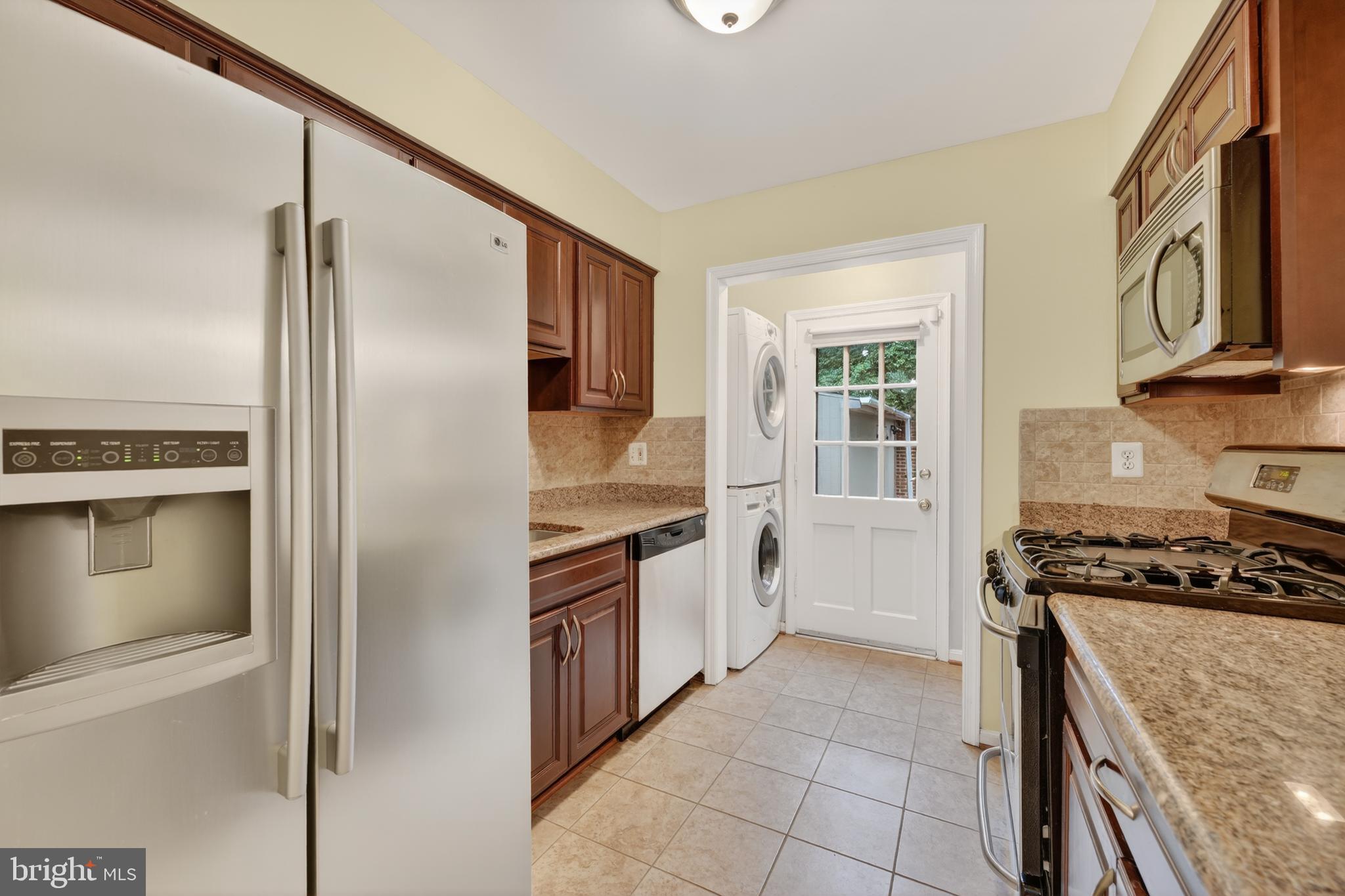 8139 Carrleigh Parkway Springfield, VA 22152 - Photo 7 of 27 a kitchen with granite countertop a refrigerator and a stove