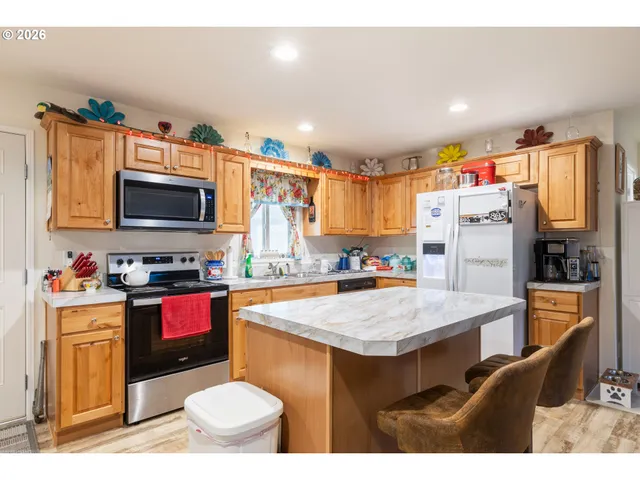 a kitchen with granite countertop a stove refrigerator and microwave