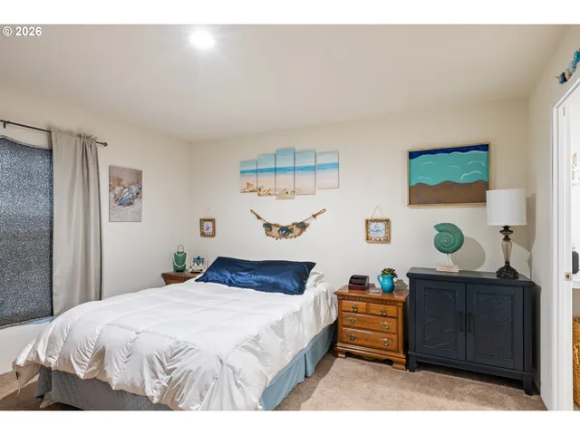 a bedroom with a large bed and wooden floor