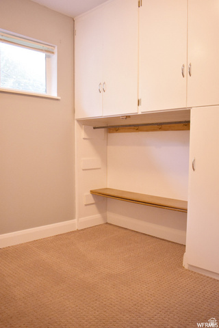 490 Averett Avenue Springville, UT 84663 - Photo 10 of 14 Built-in white cabinetry with chrome hardware, integrated bench seating, wood-finish coat rack, and textured carpeting