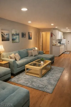 a living room with furniture and a view of kitchen