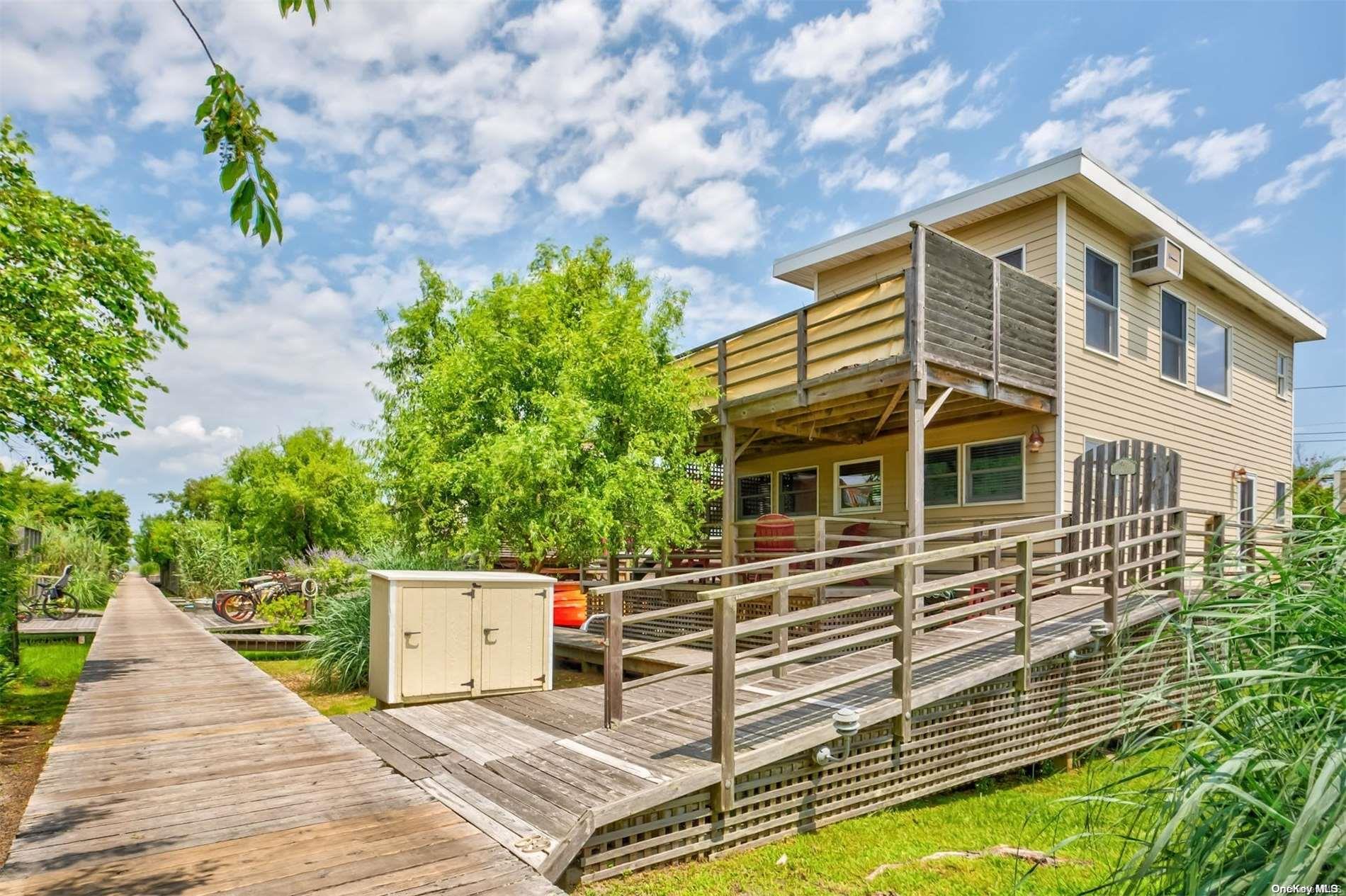 69 Walnut Walk Ocean Beach, NY 11770 - Photo 1 of 1 a front view of a house with a garden