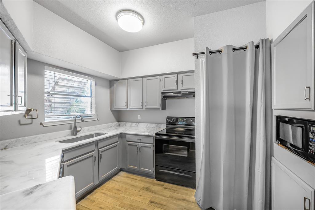 2450 Wickersham Lane, Unit M1301 Austin, TX 78741 - Photo 3 of 11 a kitchen with a sink appliances cabinets and a counter top space