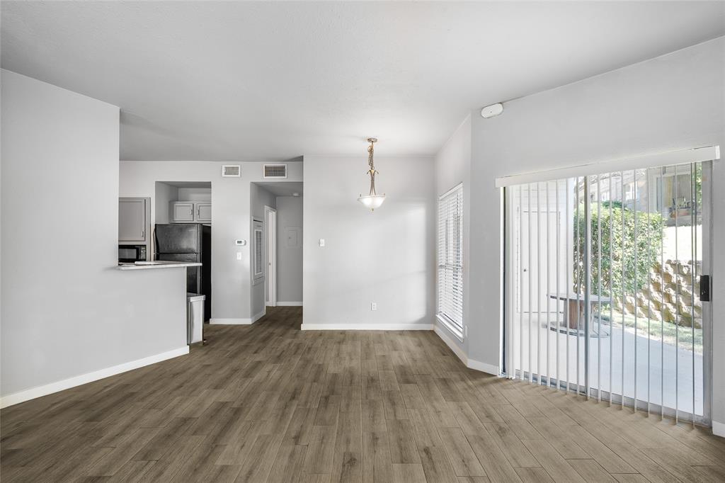 2450 Wickersham Lane, Unit M1301 Austin, TX 78741 - Photo 6 of 11 a view of a hallway with wooden floor and a living room