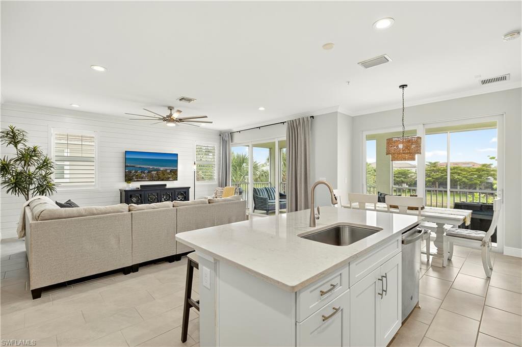 2319 Sawyers Hill Road, Unit 705 Naples, FL 34102 - Photo 12 of 29 Kitchen with white cabinets, healthy amount of natural light, light stone countertops, crown molding, and recessed lighting