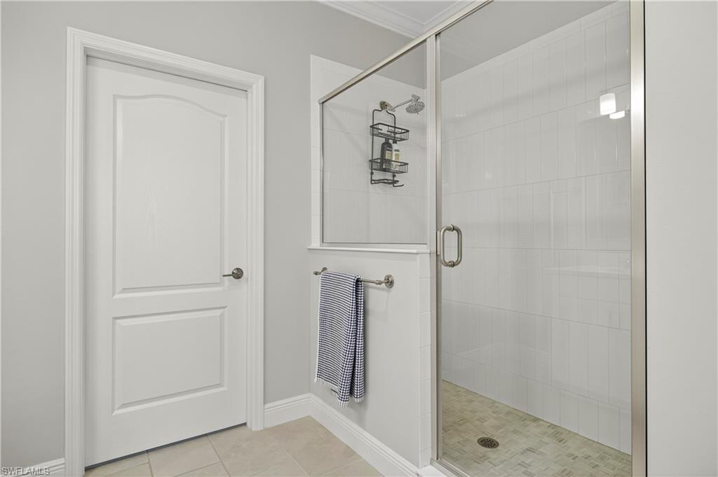 2319 Sawyers Hill Road, Unit 705 Naples, FL 34102 - Photo 17 of 29 Bathroom with a stall shower, light tile patterned floors, and ornamental molding
