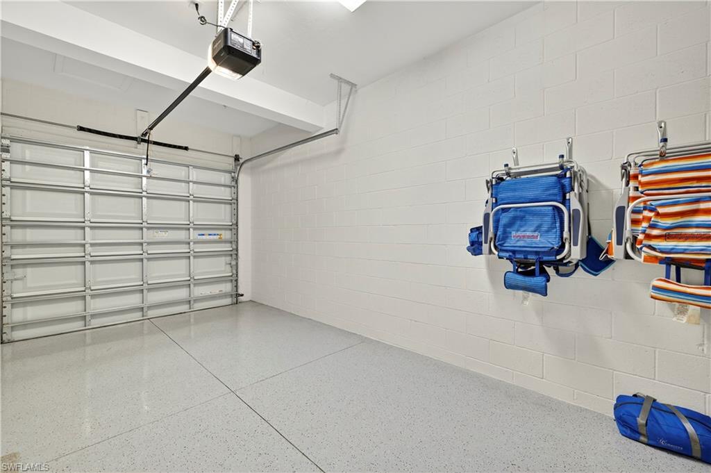 2319 Sawyers Hill Road, Unit 705 Naples, FL 34102 - Photo 24 of 29 Garage featuring concrete block wall and a garage door opener
